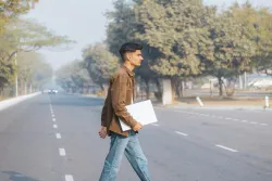 Young man crossing street