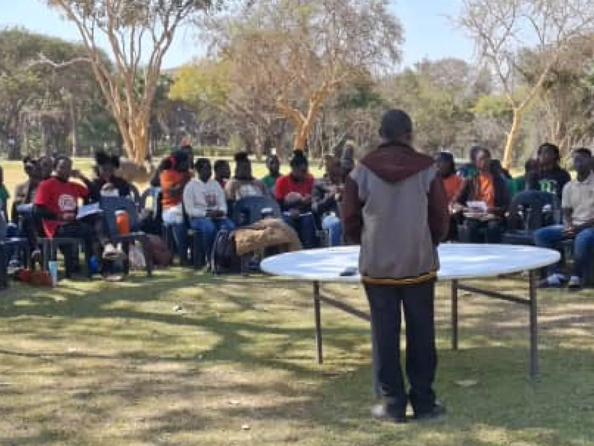 a young man teaching a crowd of people